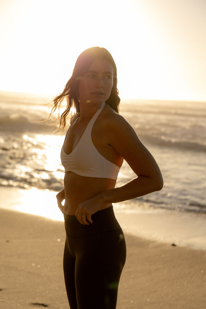 The coach is posing at the beach.