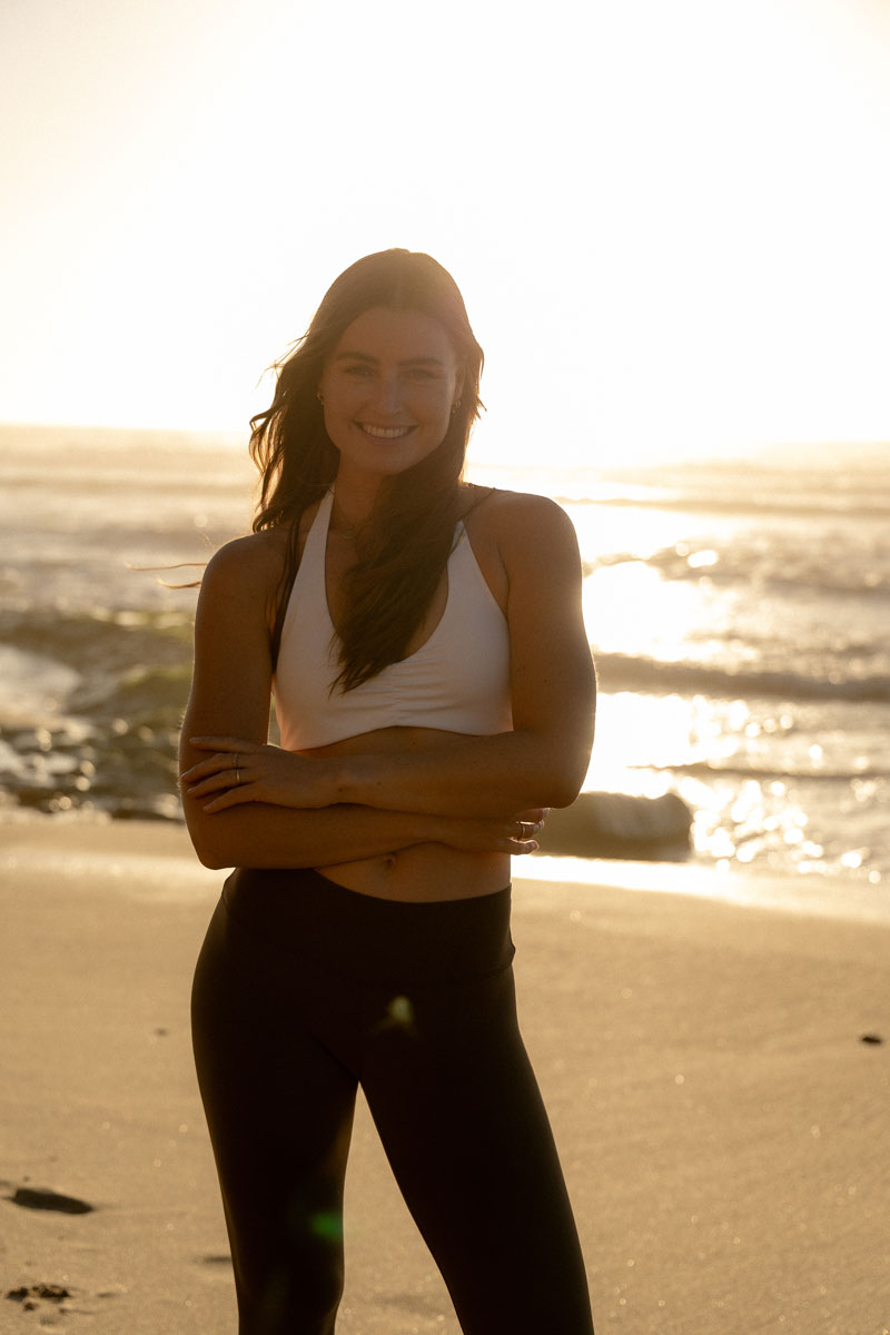 The coach is posing at the beach.